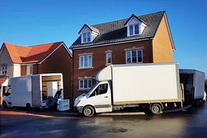 Moving trucks parked outside a residential home during a relocation